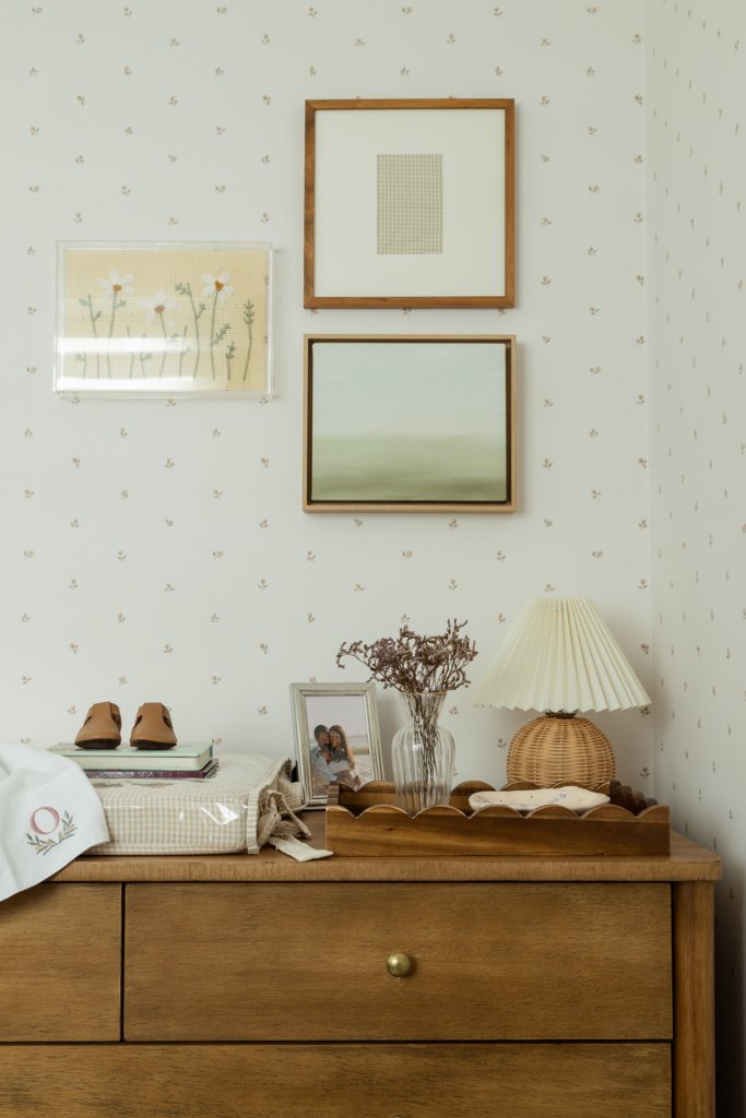 Cômoda com quadros e itens de uso mais cotidiano que fazem parte do projeto do quarto de bebê menina, da pequena Olívia.