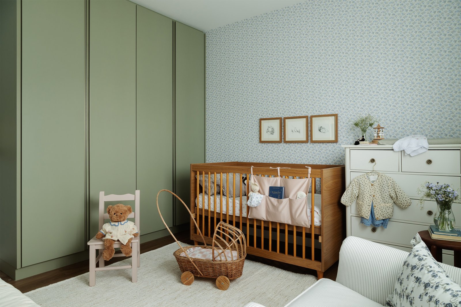 Guarda-roupa verde que é um ponto de cor bem marcante desse quarto de bebê.