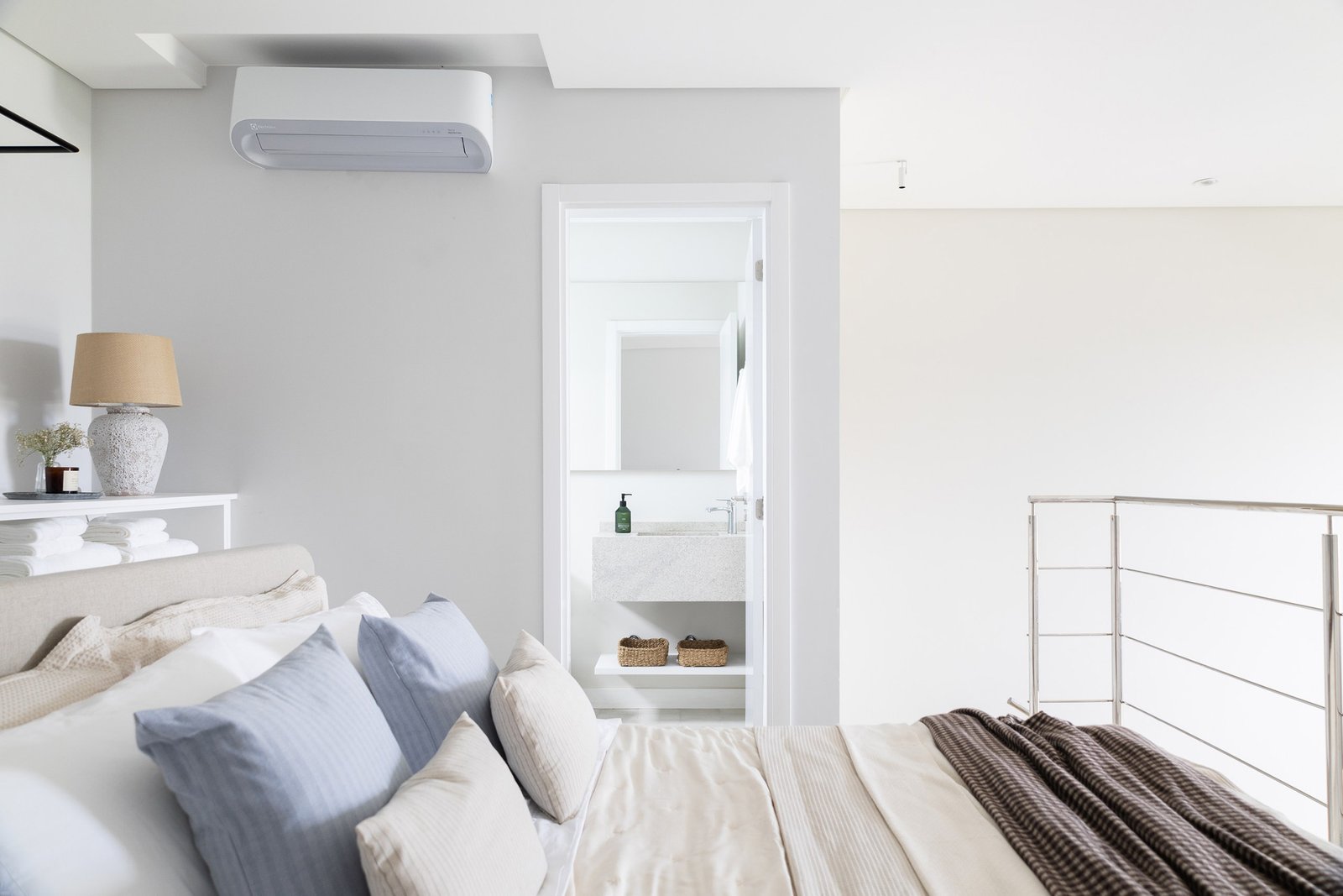 Quarto e banheiro localizados na parte superior de um loft com mezanino.
