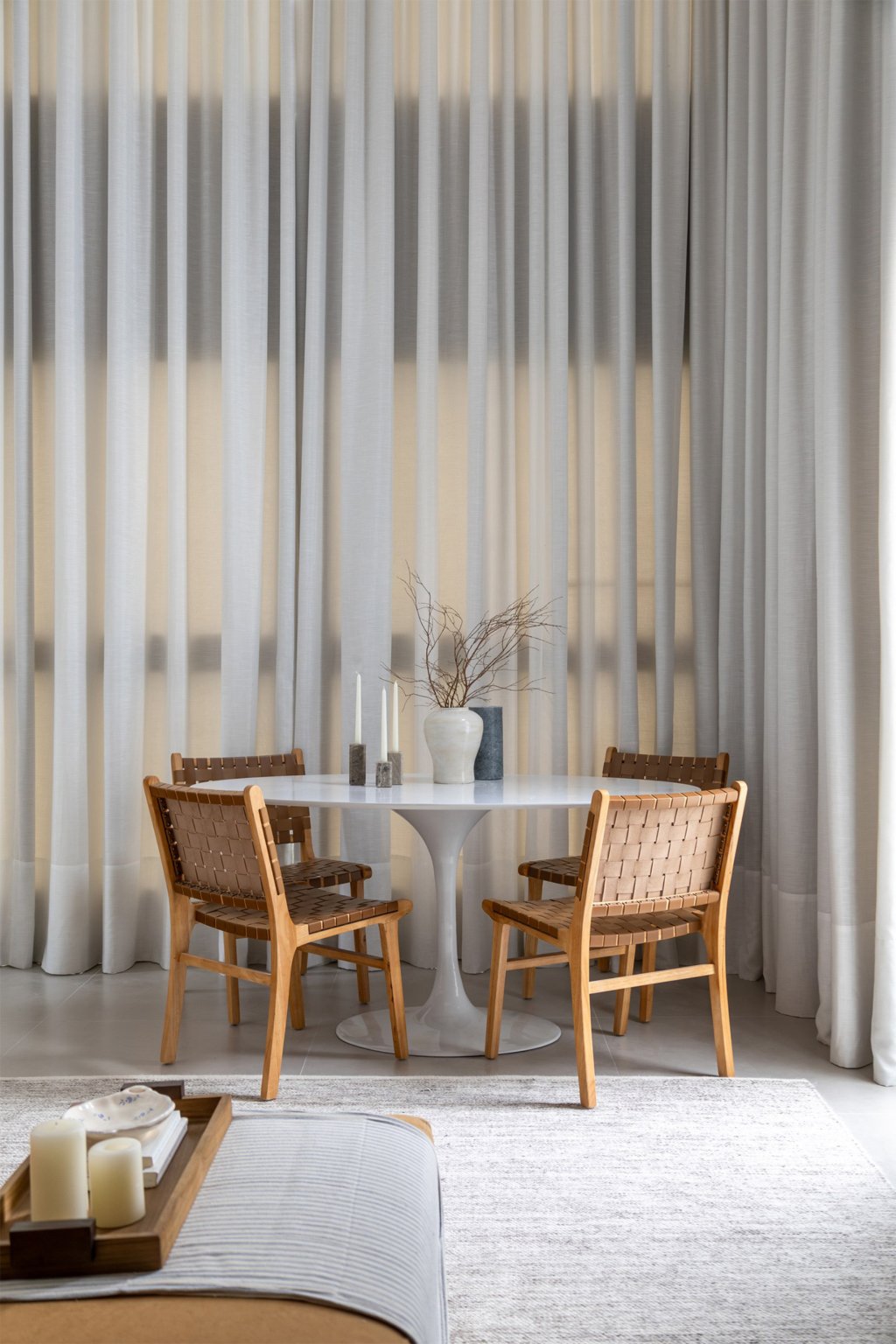 Mesa e cadeiras de jantar próximas às grandes janelas de um loft com mezanino.