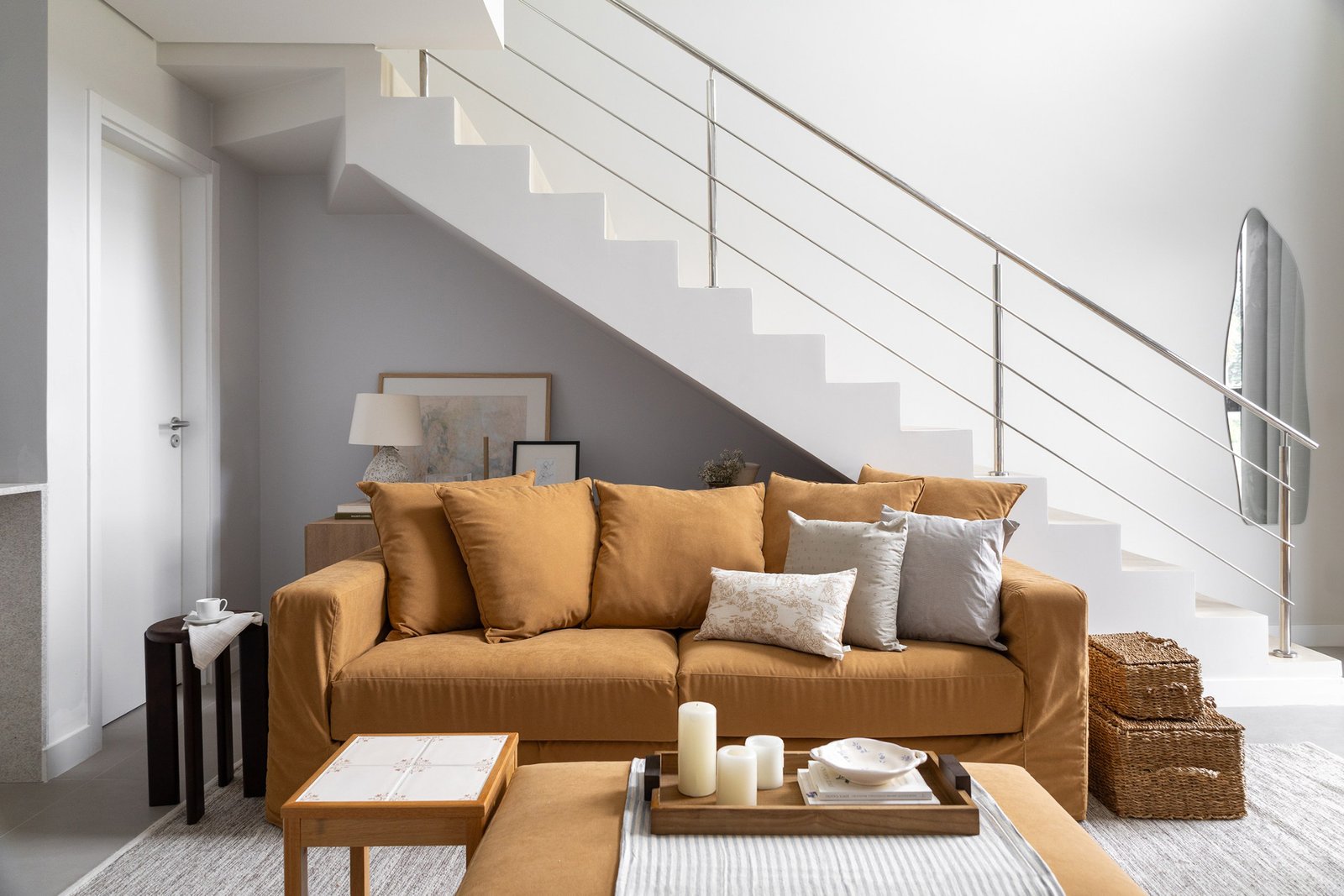 Tom mostarda do sofá traz um pouco de cor para a base neutra e leve desse loft com mezanino localizado em Florianópolis.